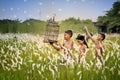 Three young men playing in the weeds carrying bird cages