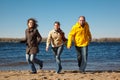 Three young men running down beach at camera Royalty Free Stock Photo