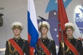 Three young military men hold flags of Russia and Moscow
