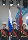 Three young military men hold flags of Russia and Moscow