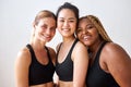 Three young multi ethnic female models of different race, hair colour and body size posing at camera