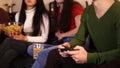 Three young people sitting on the sofa. Young man holding a joystick and women holding food