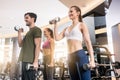 Three young people smiling while alternating dumbbell bicep curl