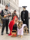 Two men dressed like hunters and a girl dressed like the Little Red Riding Hood, together with a dog dressed like a volf Royalty Free Stock Photo