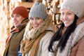 Three young people winter fashion wooden logs Royalty Free Stock Photo