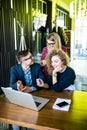 Three young people working together on a new project. Team of happy office people working on laptop computer, smiling. Royalty Free Stock Photo