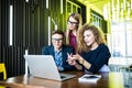 Three young people working together on a new project. Team of happy office people working on laptop computer, smiling. Royalty Free Stock Photo