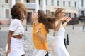 Three young smiling hipster women in summer clothes posing on street.Female showing positive face emotions. Dancing Royalty Free Stock Photo