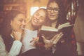 Young students girls in library reading book together. Clo Royalty Free Stock Photo