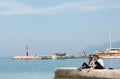 Three young teenagers sitting on the shore of the Adriatic Sea and talk. Royalty Free Stock Photo