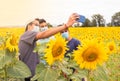 Three young teenagers taking a picture of themselves and having fun among yellow sunflowers in the countryside to send to social Royalty Free Stock Photo