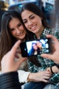 Three young woman using mobile phone at cafe shop. Royalty Free Stock Photo