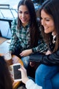 Three young woman using mobile phone at cafe shop. Royalty Free Stock Photo