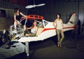 Three young women with a body plane in airplane hangar. Royalty Free Stock Photo