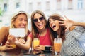 Three young women in a cafe after a shopping make selfie photo Royalty Free Stock Photo