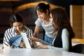 Group of young women working together with laptop and tablet in a modern workspace, discussing ideas, learning, and collaborating Royalty Free Stock Photo