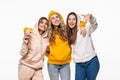 Three young women friends standing together and looking at the caemra on white background Royalty Free Stock Photo