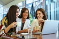 Three young women having conversation in cafe. Royalty Free Stock Photo