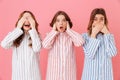 Three young women in home clothings showing symbols of tree wise