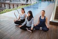 three young woman in lotus pose meditating and relaxing near swimming pool Royalty Free Stock Photo