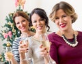 Three young women toasting with champagne