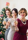 Three young women toasting with champagne