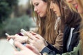 Three young women using a mobile phone in the street. Royalty Free Stock Photo