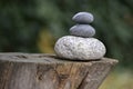 Three zen stones pile on wooden stump, white and grey meditation pebbles tower Royalty Free Stock Photo