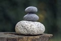 Three zen stones pile on wooden stump, white and grey meditation pebbles tower Royalty Free Stock Photo