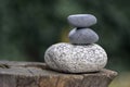 Three zen stones pile on wooden stump, white and grey meditation pebbles tower Royalty Free Stock Photo