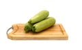Three zucchini on a cutting board on a light background.