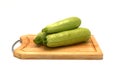 Three zucchini on a cutting board on a light background.