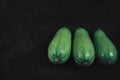 Three zucchini on a dark background. Organic eco food. Healthy diet.