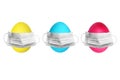 ThreeEaster colored eggs yelow blue and green colors with medical masks above isolated on a white background. Royalty Free Stock Photo