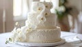 Threetiered white wedding cake with intricate lace and beaded designs adorned with white orchids on a round white cake stand Royalty Free Stock Photo
