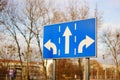 Threeway blue sign on the side of a road at daytime Royalty Free Stock Photo