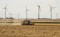 Threshing machine working on a summer field, windmill blade back