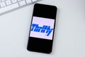 Thrifty car rental app logo on a smartphone screen.