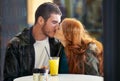 The thrill of new love. a happy young couple kissing while sitting at a cafe. Royalty Free Stock Photo