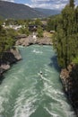 Thrill seekers zip line over the raging waters of the Bovra River located in the center of Lom during a summer afternoon