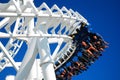 Thrill seeks zoom around a curve on a roller coaster Royalty Free Stock Photo