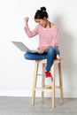 Thrilled beautiful girl sitting on a stool, enjoying her success Royalty Free Stock Photo