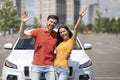 Thrilled beautiful young couple standing near new car outdoors Royalty Free Stock Photo