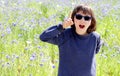 Thrilled expressive child with sunglasses over sunny cornflower meadow, outdoor