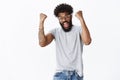 Thrilled and overwhelmed handsome energized african american male fan in glasses with piercing and tattoos yelling in Royalty Free Stock Photo