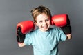 Thrilled young boy giggling with boxing gloves up for fight