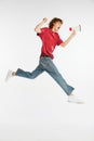 Thrilled young man jumping and shouting at loudspeker isolated over white background. News, sport, dance, fitness Royalty Free Stock Photo