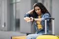 Thrilled young woman tourist checking time, got late for flight