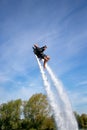 Thrillseeker, athlete strapped to Jet Lev, levitation soars into a blue sky with whispy clouds