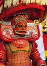 A Theyyam artist is adorned with traditional colorful costume before a performance at the festival in Kannur, Kerala, India.